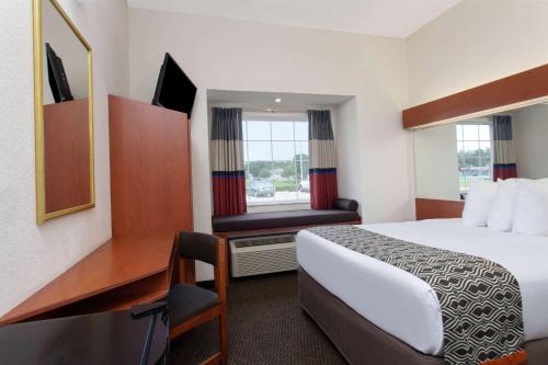 a hotel room with a bed and a desk at Microtel Inn and Suites by Wyndham - Lady Lake/ The Villages in The Villages