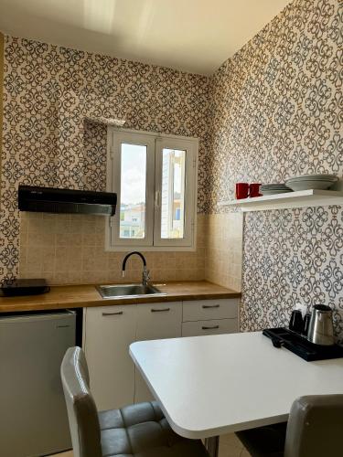 a kitchen with a white table and a sink at Nautica Hotel Apartments in Stavromenos