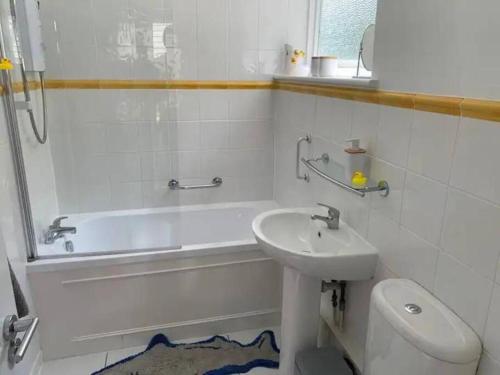 ein Badezimmer mit Waschbecken, Badewanne und Toilette in der Unterkunft Jurassic Coast Holiday Home in Charmouth