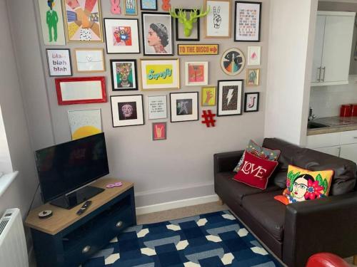 a living room with a couch and a wall of pictures at Jurassic Coast Holiday Home in Charmouth