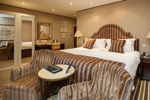 a hotel room with a bed and a couch at The Old Government House Hotel & Spa in St Peter Port