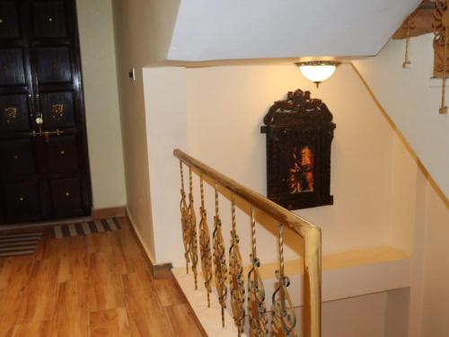 a hallway with a staircase with a clock on the wall at Satshree Kothi in Varanasi
