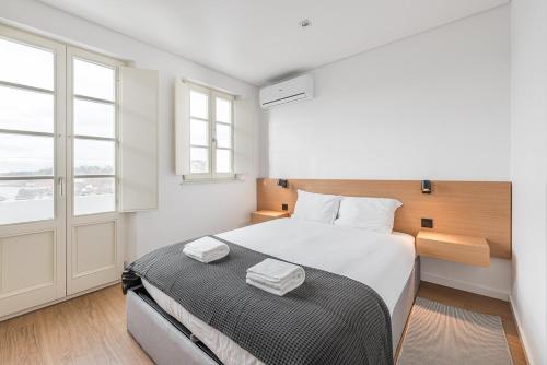 ein Schlafzimmer mit einem großen Bett und einem Fenster in der Unterkunft GuestReady - Riverview Douro Balcony in Vila Nova de Gaia