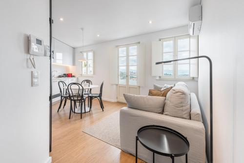 ein Wohnzimmer mit Sofa und Tisch in der Unterkunft GuestReady - Riverview Douro Balcony in Vila Nova de Gaia