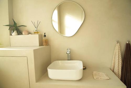une salle de bain avec un lavabo et un miroir au mur dans l'établissement Triplex lumineux avec balcon - 500m Champs Elysées, à Paris