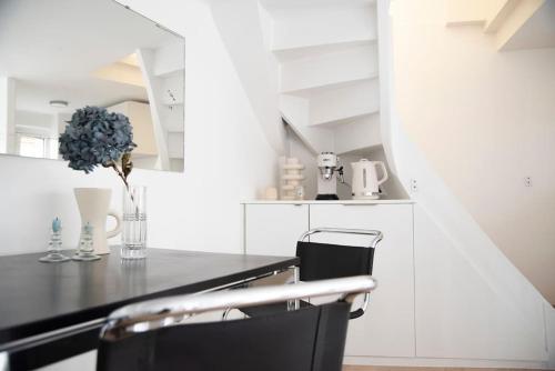 une cuisine avec un comptoir noir et une chaise noire dans l'établissement Triplex lumineux avec balcon - 500m Champs Elysées, à Paris