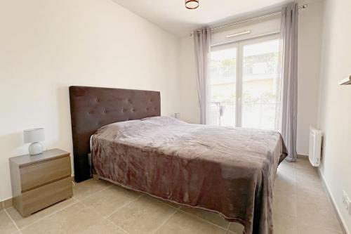 une chambre avec un grand lit et une fenêtre dans l'établissement Le Valley, à Nice