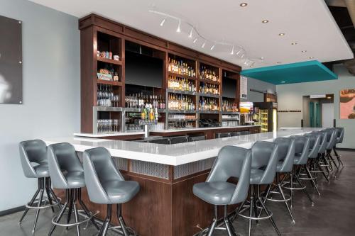 a bar with a row of gray stools at Hampton Inn & Suites Madison Downtown in Madison