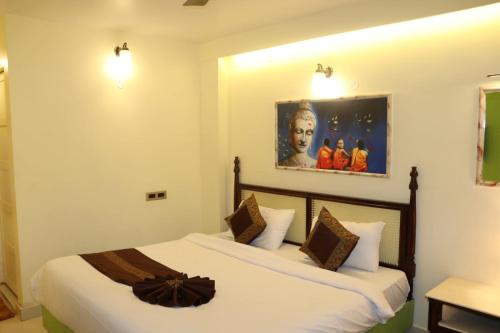 a bedroom with a bed and a painting on the wall at Satshree Kothi in Varanasi