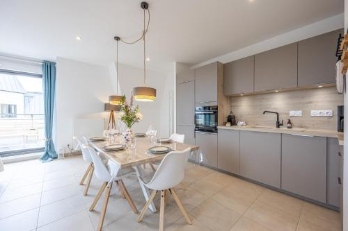 une cuisine et une salle à manger avec une table et des chaises dans l'établissement Le Vertigo - Appt proche de la plage, à Dinard
