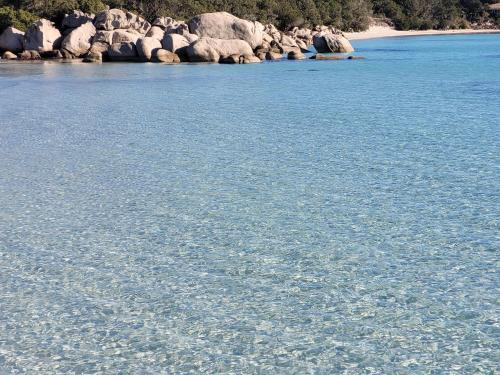 a large body of water with rocks in the background at ARGIALE - ARGHJALE in Figari