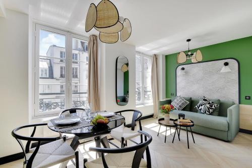 un salon avec une table, des chaises et un canapé dans l'établissement SERENERS - Charming Serviced Apartments - Bastille, à Paris