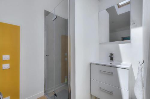 une salle de bain blanche avec un lavabo et une douche dans l'établissement L'Ormeau - Charmant appt pour 4, à Toulouse