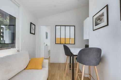 un salon avec un canapé blanc et une table dans l'établissement L'Ormeau - Charmant appt pour 4, à Toulouse