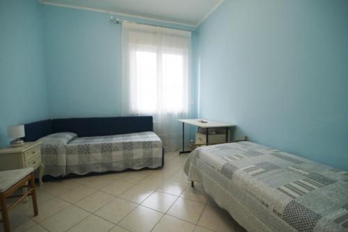 a blue room with two beds and a window at Luminose Camere a San Martino in Genova