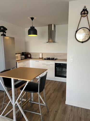 une cuisine avec une table et des chaises en bois dans l'établissement Le Lanroz beau T2 dans résidence privée Lambezellec, à Brest