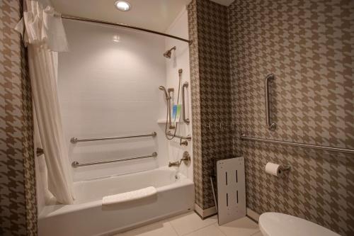 a bathroom with a white tub and a toilet at Home2 Suites By Hilton Charlotte Uptown in Charlotte