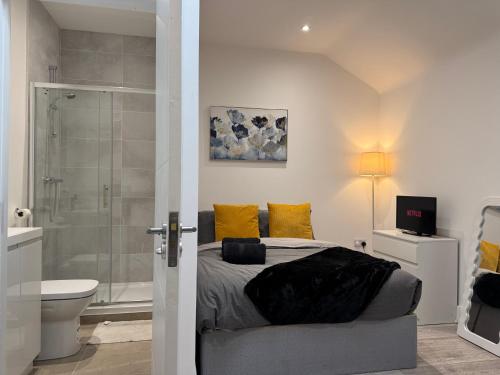 a bedroom with a bed and a bathroom with a shower at New! Bright, Cosy & Central With Skylight & Smart TV in Maidstone