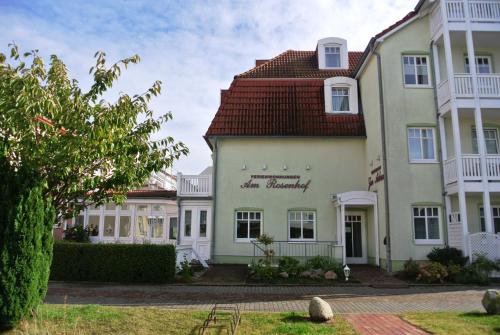 ein großes weißes Gebäude mit rotem Dach in der Unterkunft Fewo Rosenhof 03 in Kühlungsborn