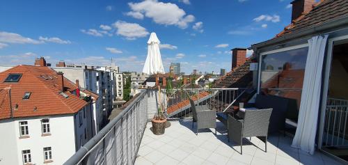 a balcony with chairs and a view of a city at coLodging Mannheim - private rooms & kitchen in Mannheim
