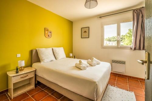 a bedroom with a bed with yellow walls and a window at OIQIA • Occitane in Carcassonne