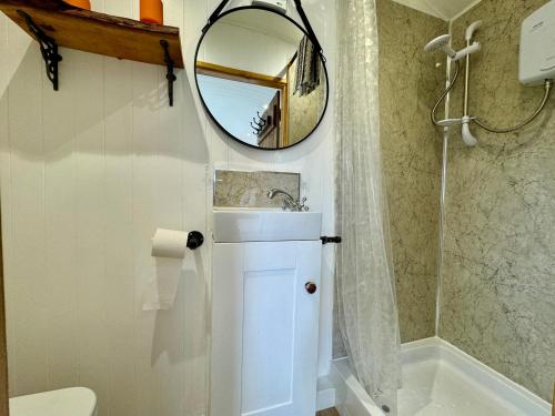 a bathroom with a sink and a mirror at Mooffitch Riverview Hut in Gloucester