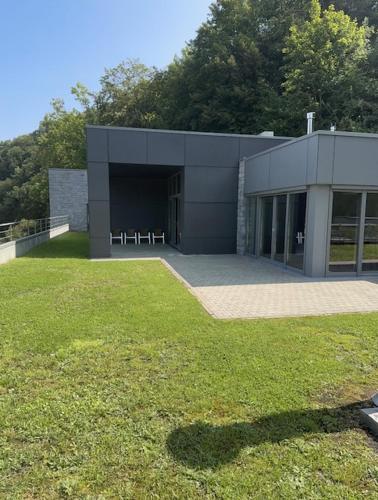 a large building with a grassy yard in front of it at Hôtel WELLNESS EAU DE ROCHE Durbuy in Durbuy