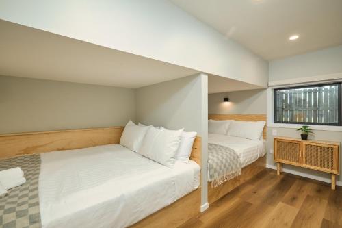 a bedroom with two beds and a window at Modern Mountain Views Sunny in Kaikoura