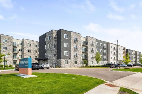 a large building with cars parked in a parking lot at WaterWalk Extended Stay by Wyndham Minneapolis - Plymouth in Plymouth
