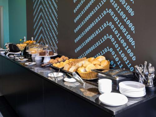 a buffet line with bread and pastries on a table at Ibis Styles Barretos in Barretos