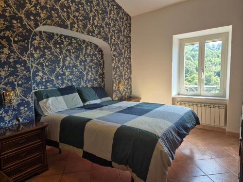 a bedroom with a bed with a blue patterned wall at La Casa Dei Principi - A in Genazzano