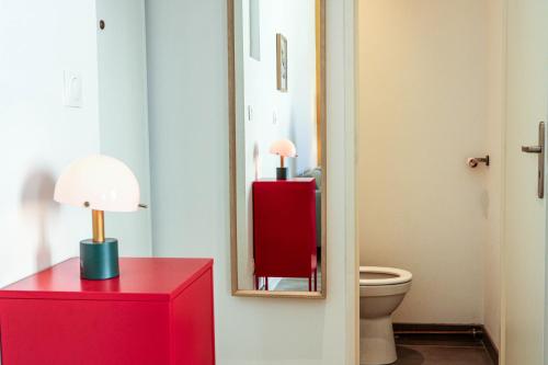 a bathroom with a red dresser and a mirror at Bel appartement moderne à Villeurbanne in Villeurbanne