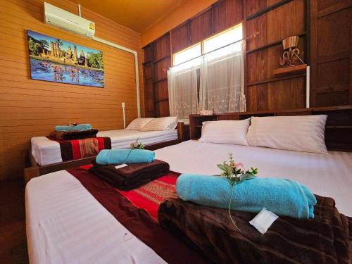 Postel nebo postele na pokoji v ubytování บ้านเรือนไทยมะลิเมืองเก่า
