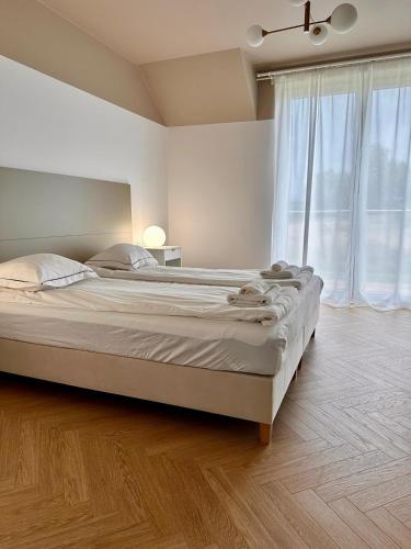 a bedroom with a large bed and a large window at Apartamenty przy Winnicy in Busko-Zdrój