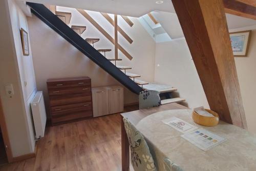 a staircase in a room with a table and a stair case at Apartment 4 Zum Kuhstall Heinrichsberg - Magdeburg in Niegripp