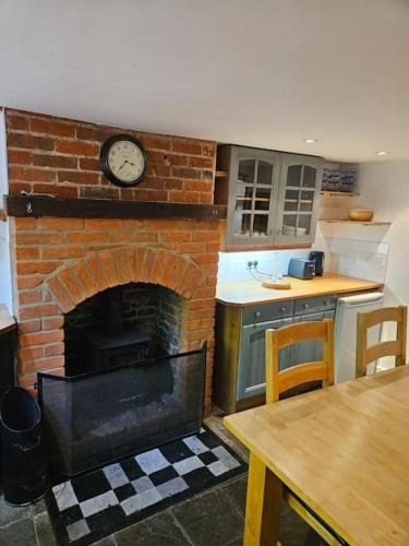 a kitchen with a brick fireplace with a clock on it at House in historic Winchester in Winchester