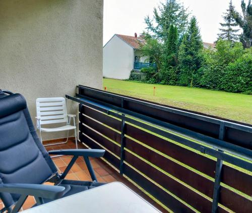 a balcony with two chairs and a field of grass at Wohnung Isarnähe in Wackersberg