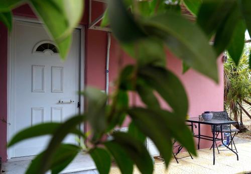 a pink house with a white door and a table at Casa Kobo in Agios Ioannis