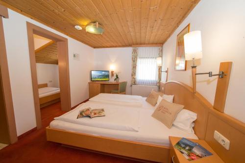 a bedroom with a large bed with a wooden ceiling at Hotel Glasererhaus in Zell am See