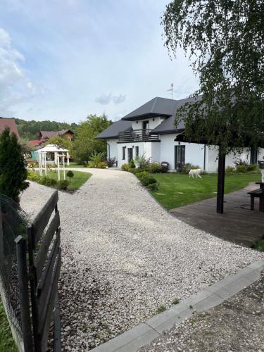 a house with a fence and a gravel driveway at Leśne Zacisze Sochy in Zwierzyniec