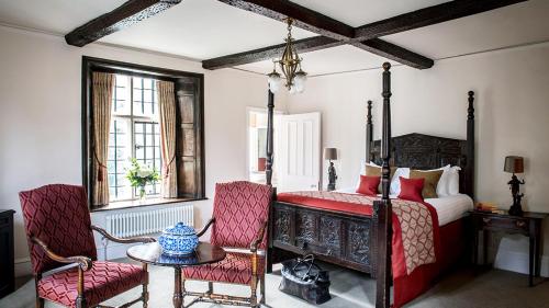 a bedroom with a bed and a table and chairs at New Hall Hotel & Spa, Birmingham in Birmingham