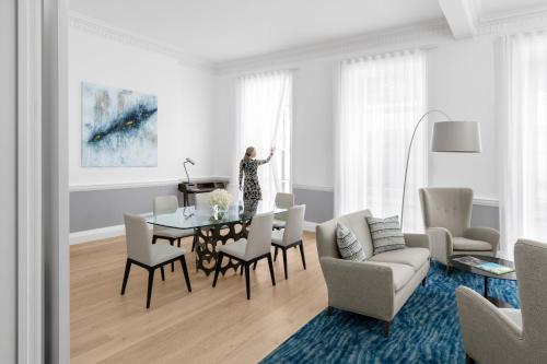 a woman standing in a living room with a table at COMO Metropolitan London in London