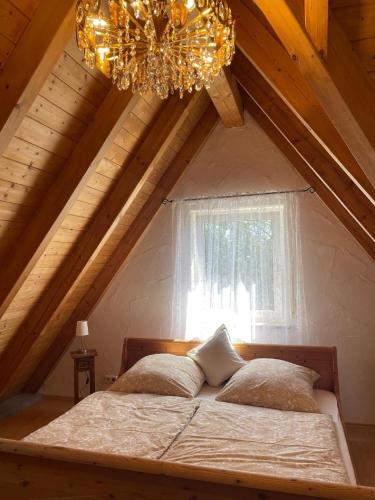 a bedroom with a bed in a attic with a chandelier at Apartment am Ronhof in Fürth