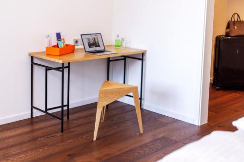 a desk with a chair and a laptop on it at schlossmühle - lean luxury boutique hotel in Glottertal