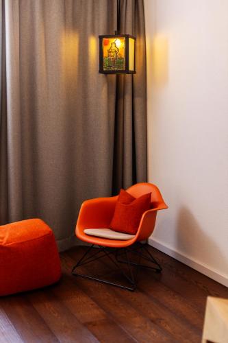 an orange chair sitting in front of a curtain at schlossmühle - lean luxury boutique hotel in Glottertal