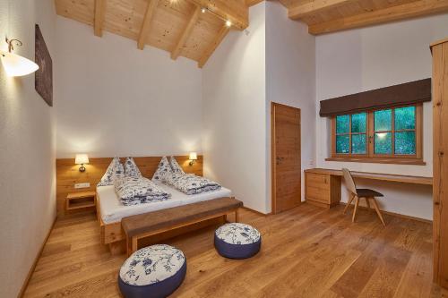 ein Schlafzimmer mit einem Bett und einem Schreibtisch in einem Zimmer in der Unterkunft Berg- & Seeblick Pfefferbauer in Zell am See