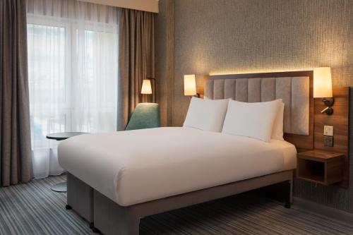a hotel room with a large bed and a window at DoubleTree by Hilton London Chelsea in London