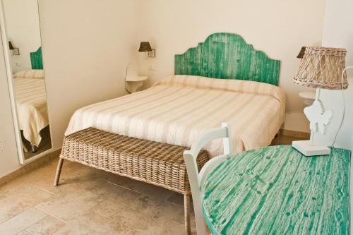 a small bedroom with a bed and a table at B&B Alalama in Polignano a Mare