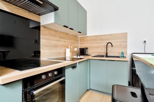 une cuisine avec des armoires blanches et un évier dans l'établissement Modern 1BR Flat in the heart of Lille, à Lille