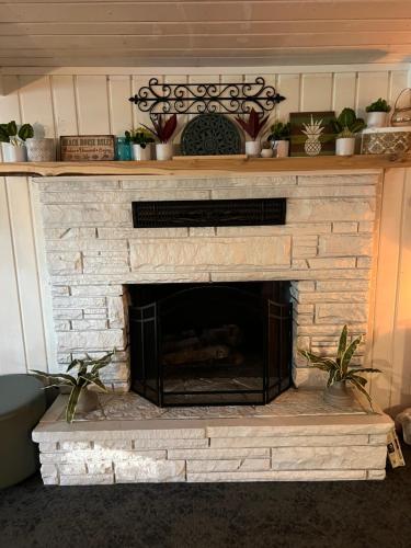 a stone fireplace with plants on top of it at LakeHouse Inn in Houghton Lake